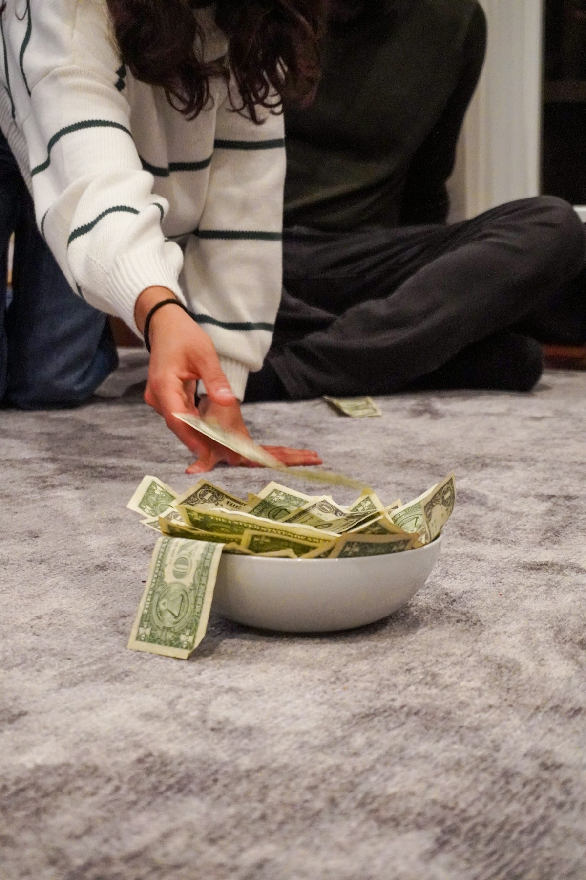 A woman reaching for money in a bowl