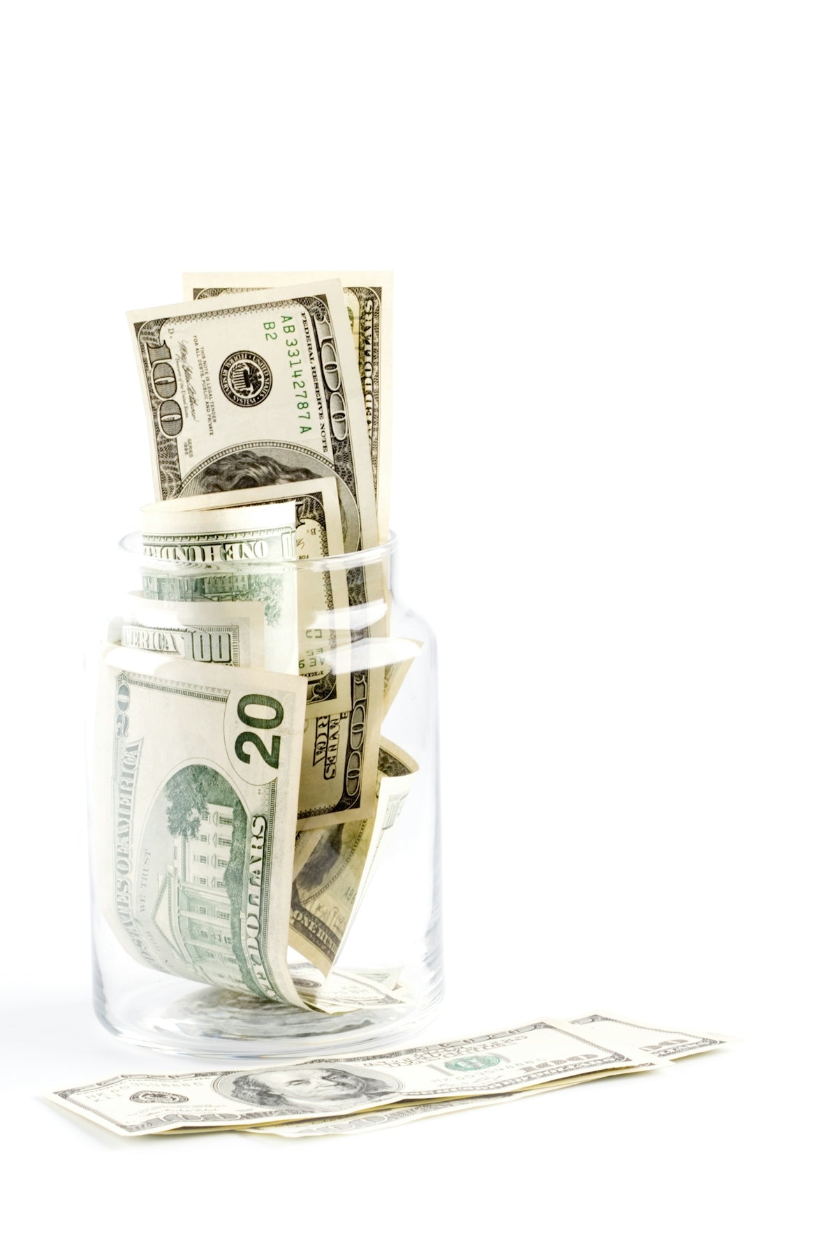 A glass jar filled with money sitting on top of a table