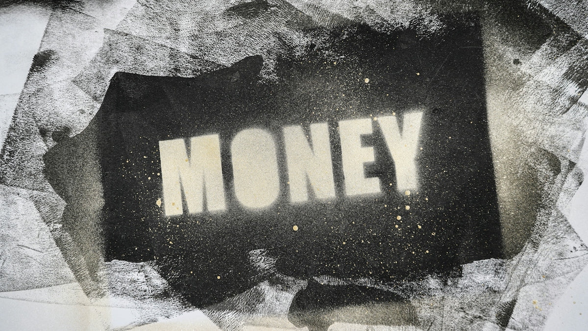 The word MONEY stenciled in white letters over a textured black spray paint background